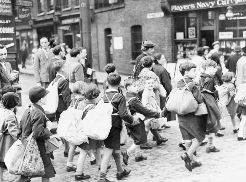 The Civilian Evacuation Scheme in Britain during the Second World War Young children from the East End of London carrying their belongings, including their gas masks, as they set off on their journey to safer areas. Date between 1939 and 1945. Imperial War Museum.